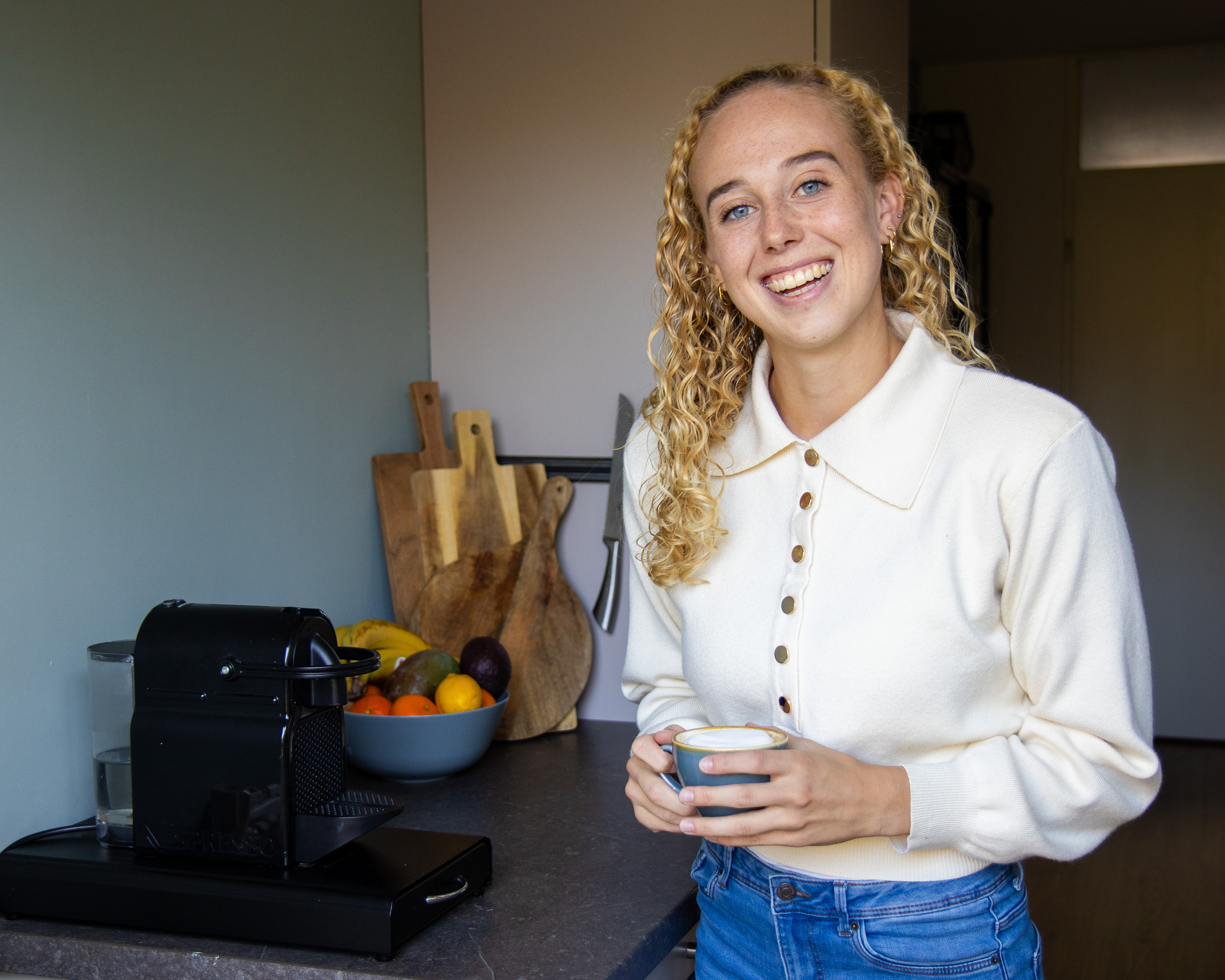 Meisje in keuken met kop koffie